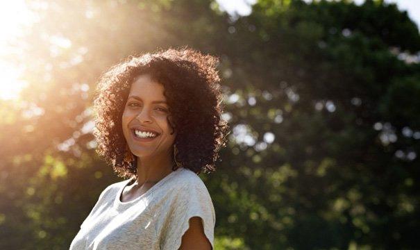 Woman smiling over the benefits of dental implants in Newton 