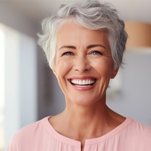 Middle-aged woman smiling confidently with dental implants 
