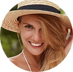 Woman in sunhat smiling outdoors