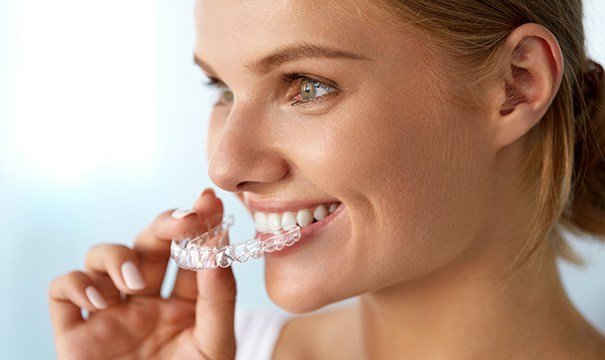 Woman placing Invisalign tray