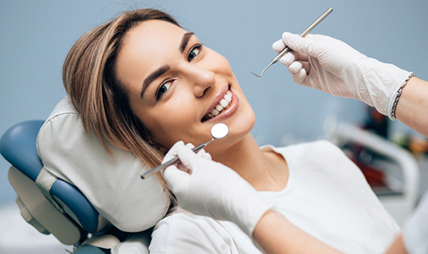 Happy woman at dental checkup to prevent toothaches
