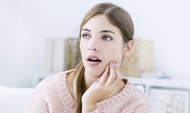 Woman holding cheek in pain