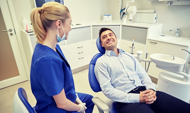 man in blue dress shirt smiling in the dental chair