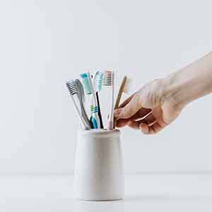 Hand taking toothbrush out of holder