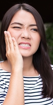 Woman holding jaw in pain