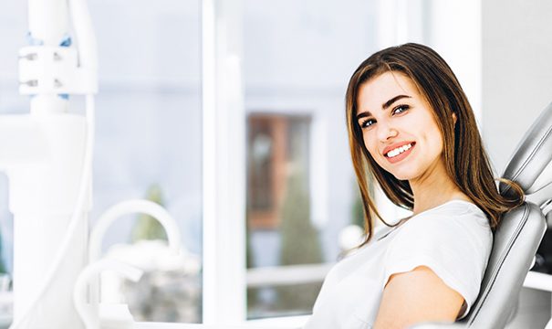 Woman sitting in dental chair smiling
