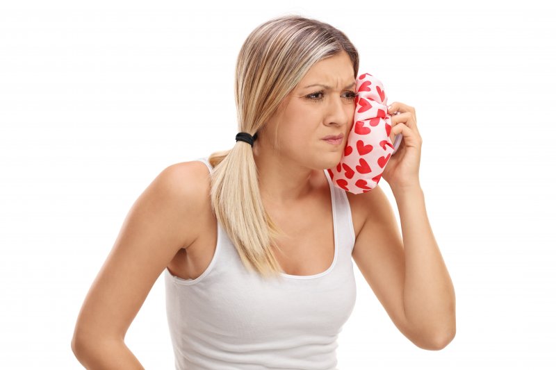 woman holding ice pack to her jaw