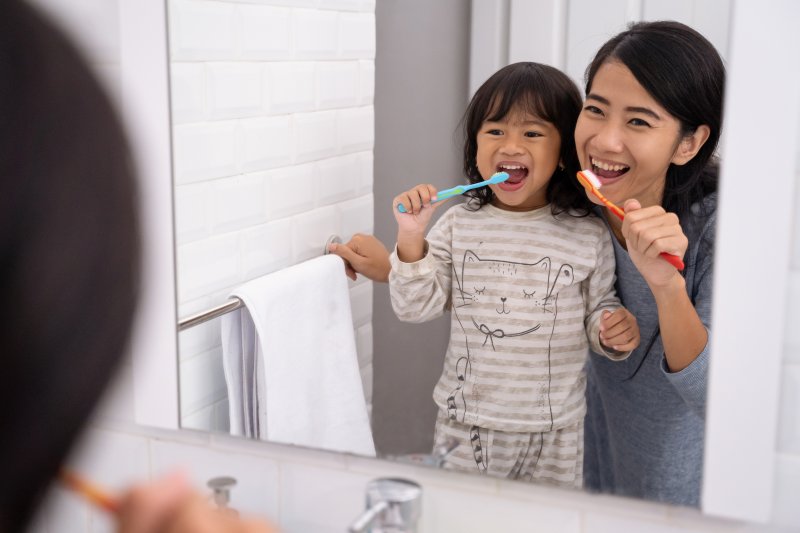 Mom and daughter brushing their teeth