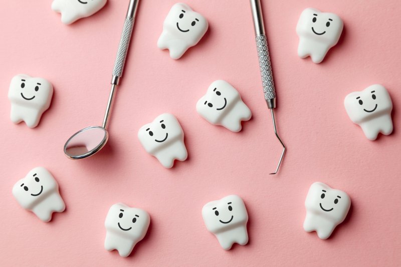 Cartoon smiling molars lying next to dental tools