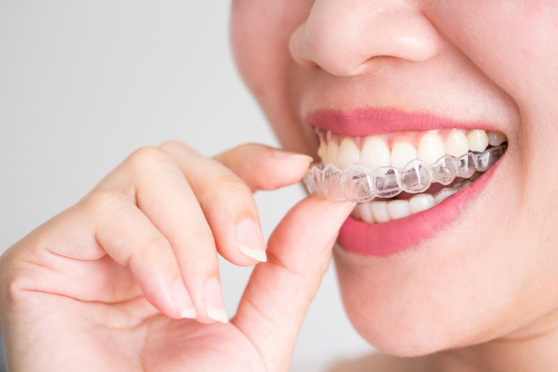 an up-close view of a person inserting their Invisalign aligner