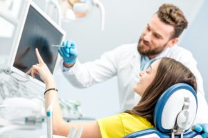 dentist showing patient wisdom teeth x-rays