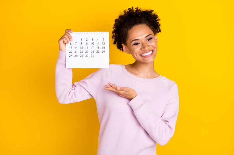 woman smiling and holding a calendar