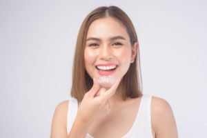 a woman smiling with her aligners