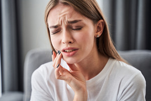 Woman in white shirt with a painful toothache