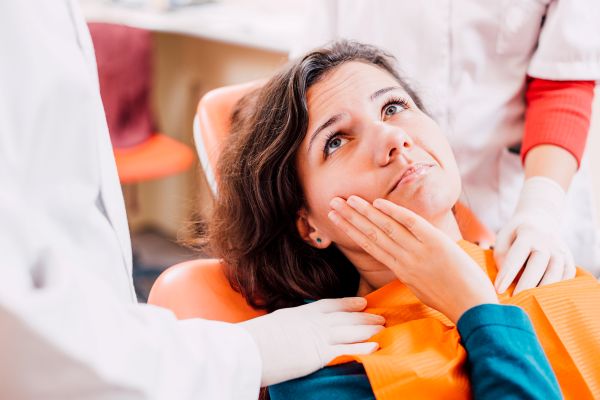 A woman at the dentist with a toothache